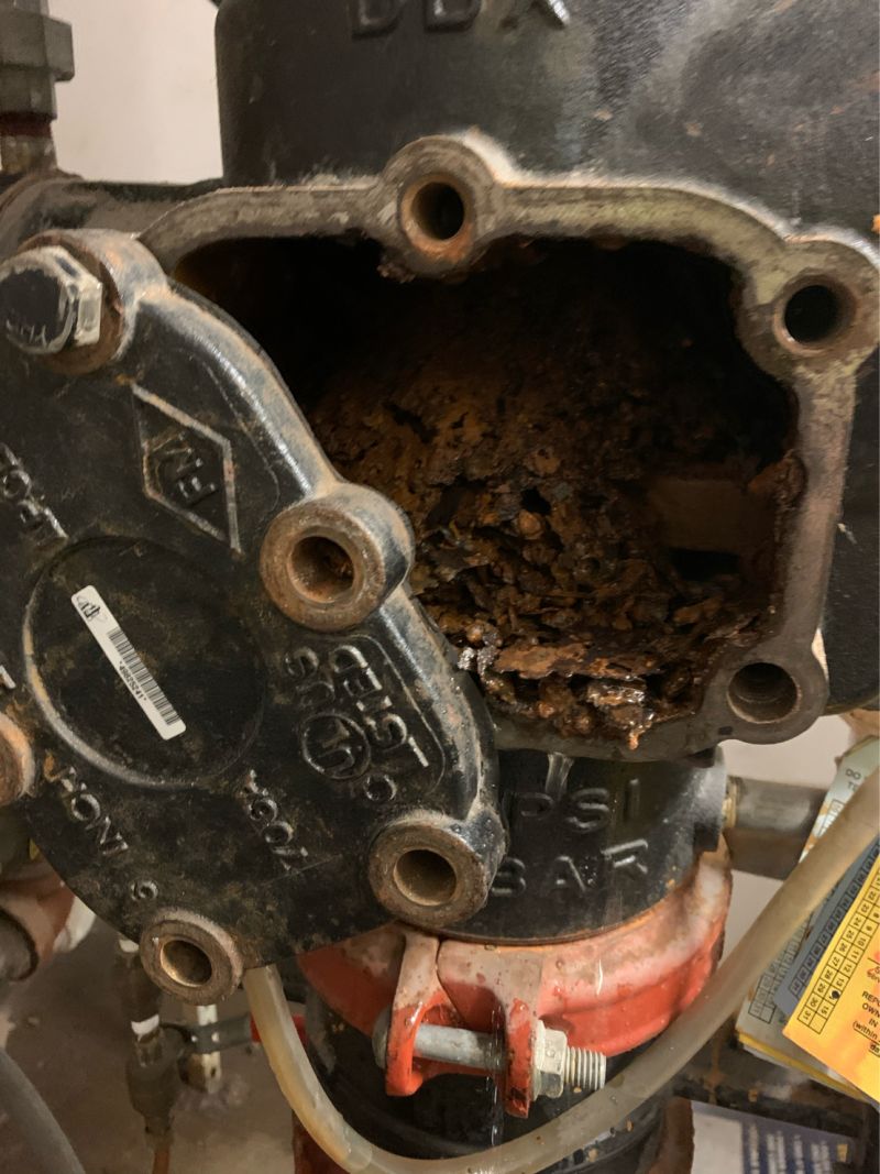Poste de contrôle sprinkler ouvert lors d’une maintenance : la chambre interne est comblée par un dépôt de rouille feuilletée qui obstrue le passage de l’eau.